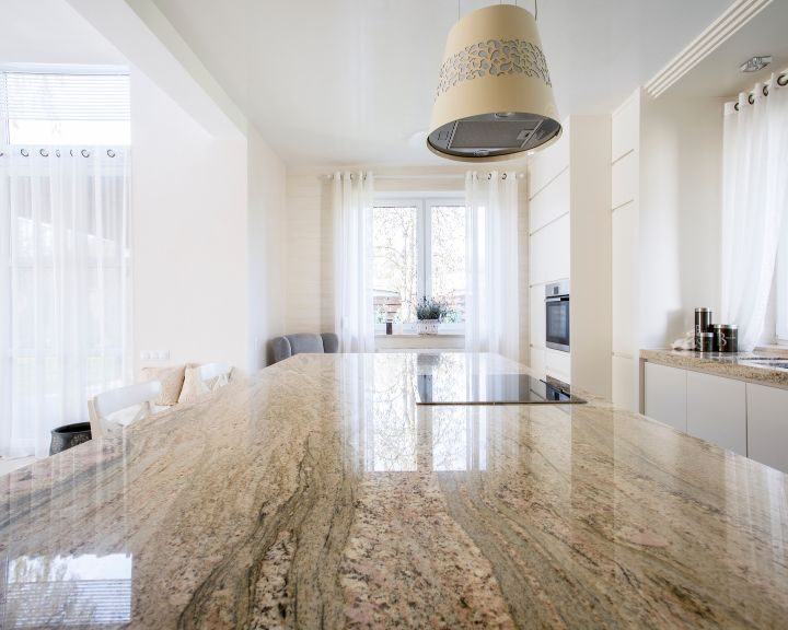 a large kitchen with a marble counter top.