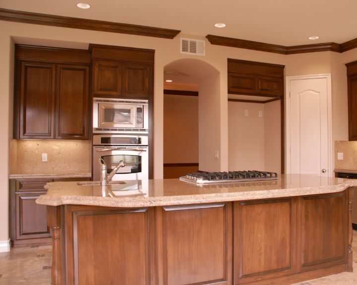 a kitchen with a stove, oven, microwave and cabinets.