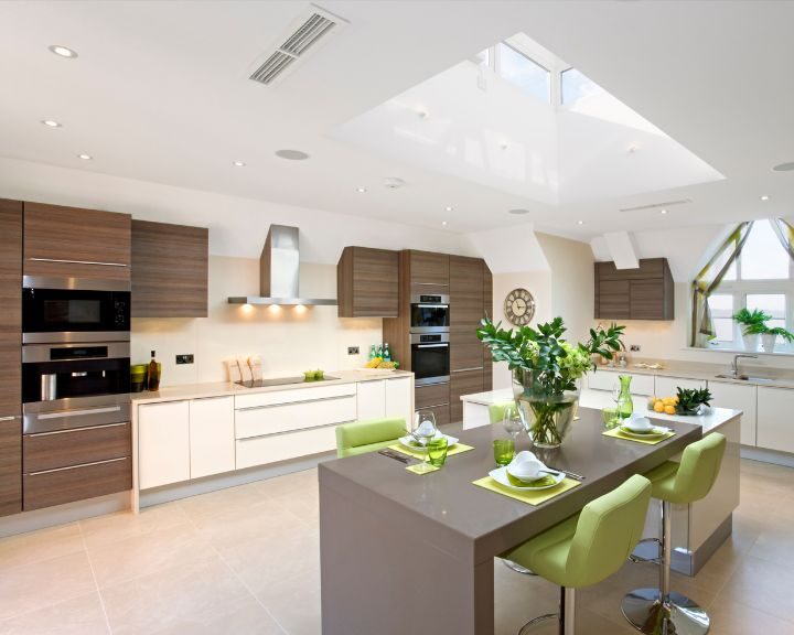 a large kitchen with a center island with green chairs.