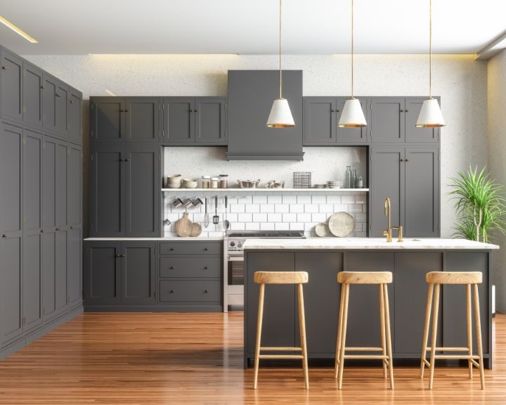 a large kitchen with gray cabinets and wooden floors.