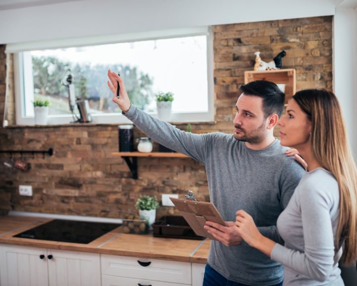 a man and a woman standing in a kitchen.