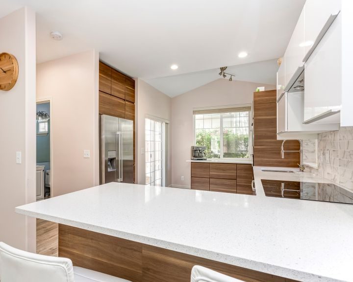 a kitchen with a white counter top and wooden cabinets.